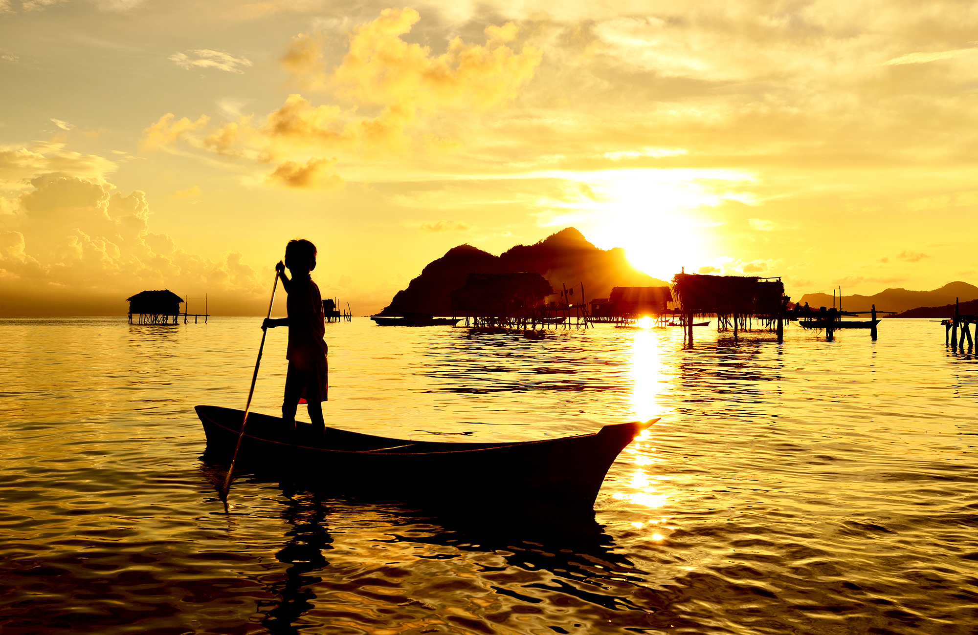 borneo-sabah-semporna-maiga-island-kid-paddling-on-a-boat-near-bajau-laut-village-cover