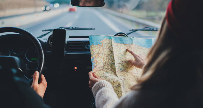girl on a road trip reading a map