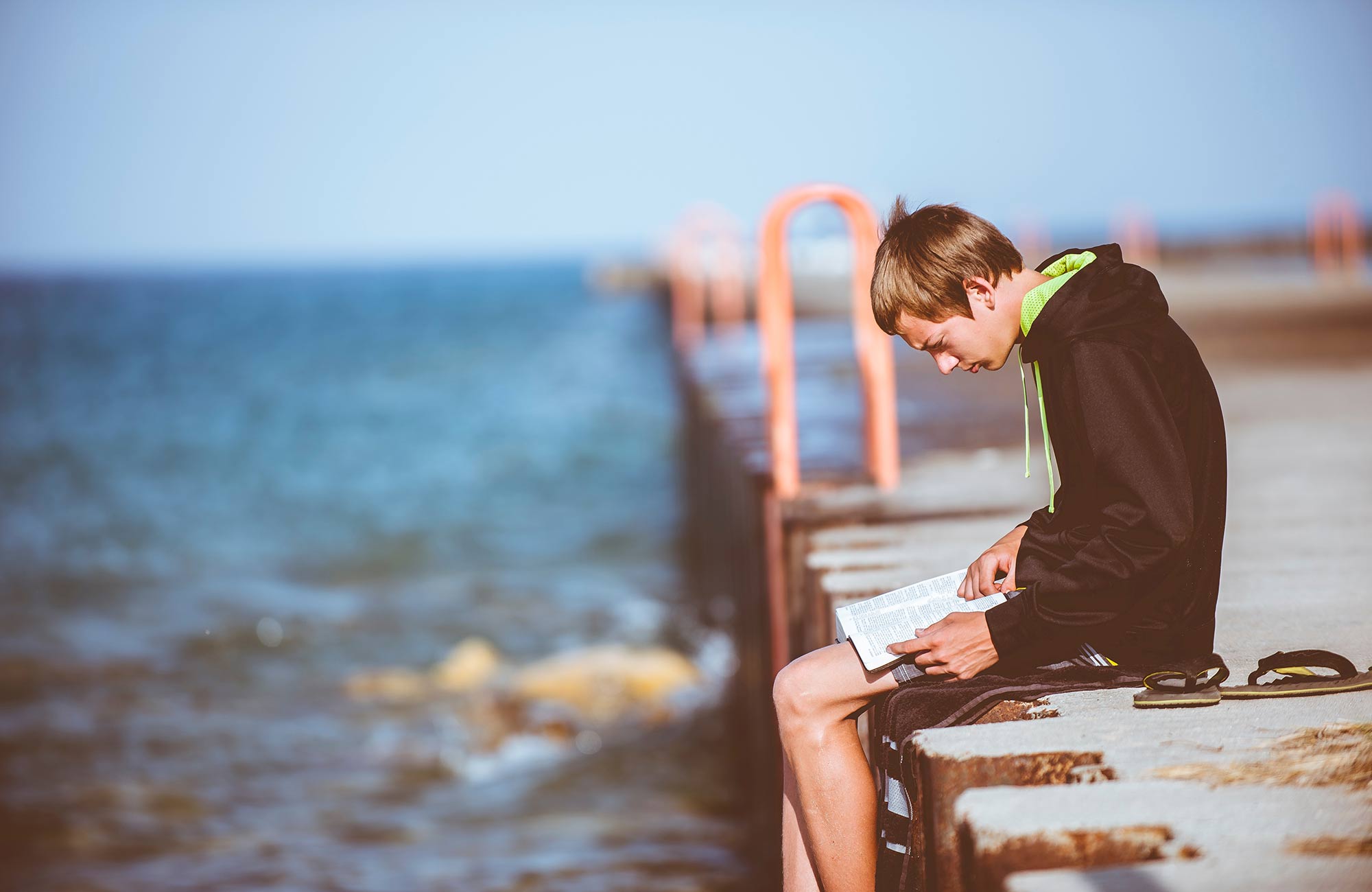 education-guy-reading-on-pier