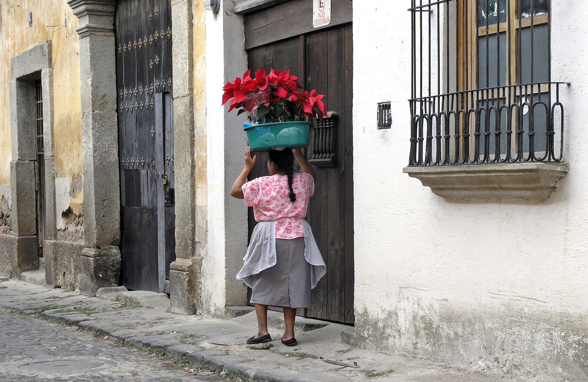 antigua-guatemala-woman-carrying-flowers-street-cover
