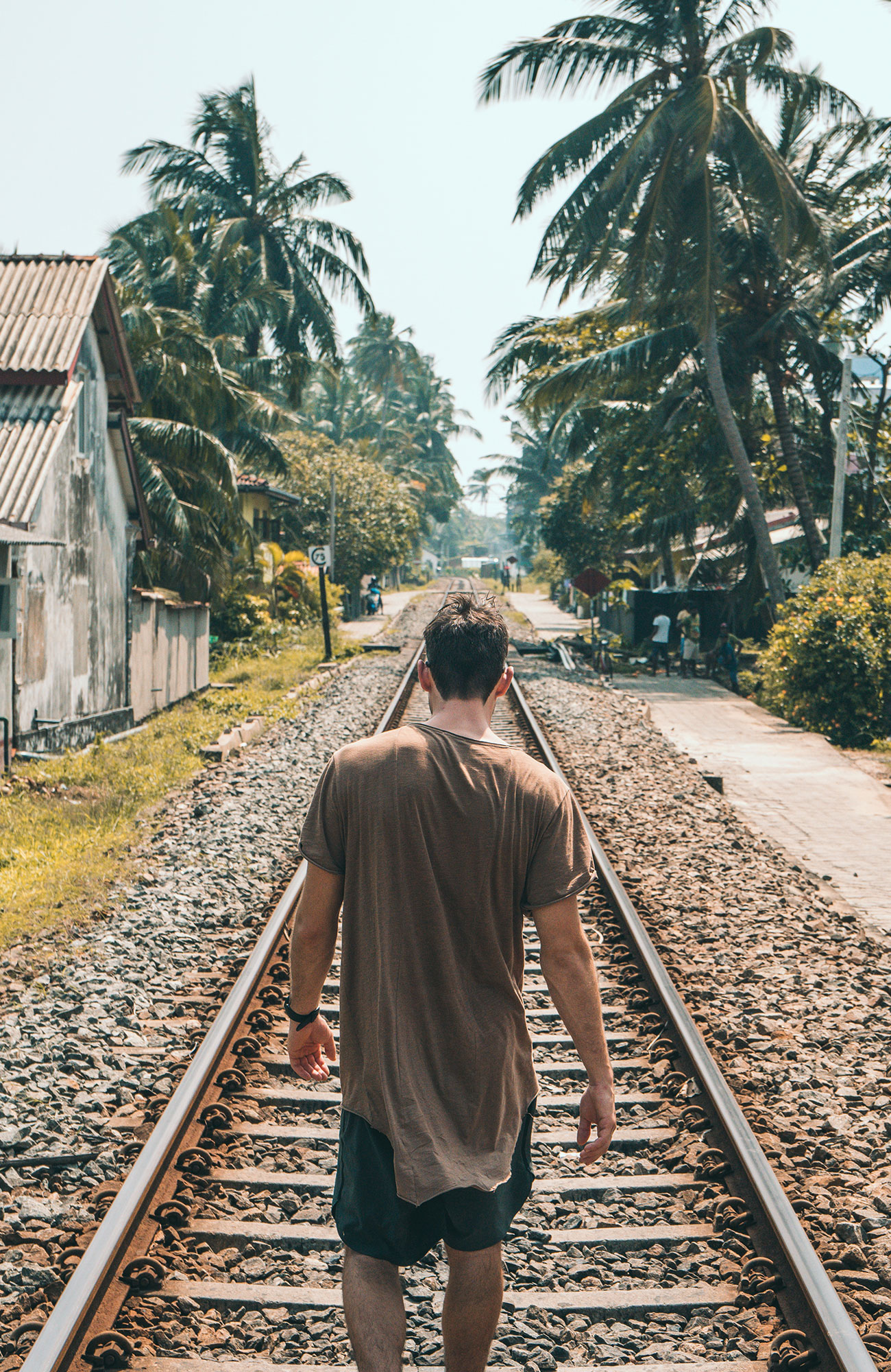 Guy walking on train tracks in Asia 