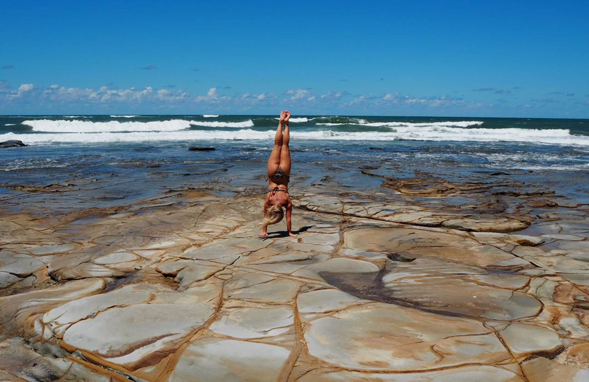 malin an exchange student in australia is doing a handstand at the beach