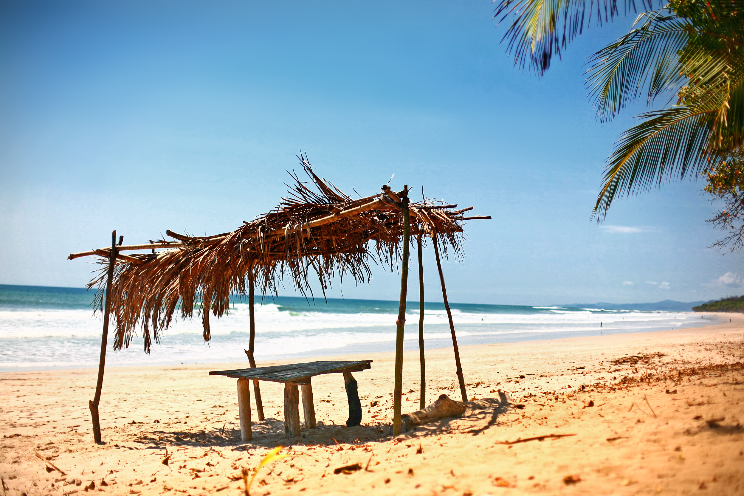 Small improvised pergola on a sunny and sandy beach in Costa Rica