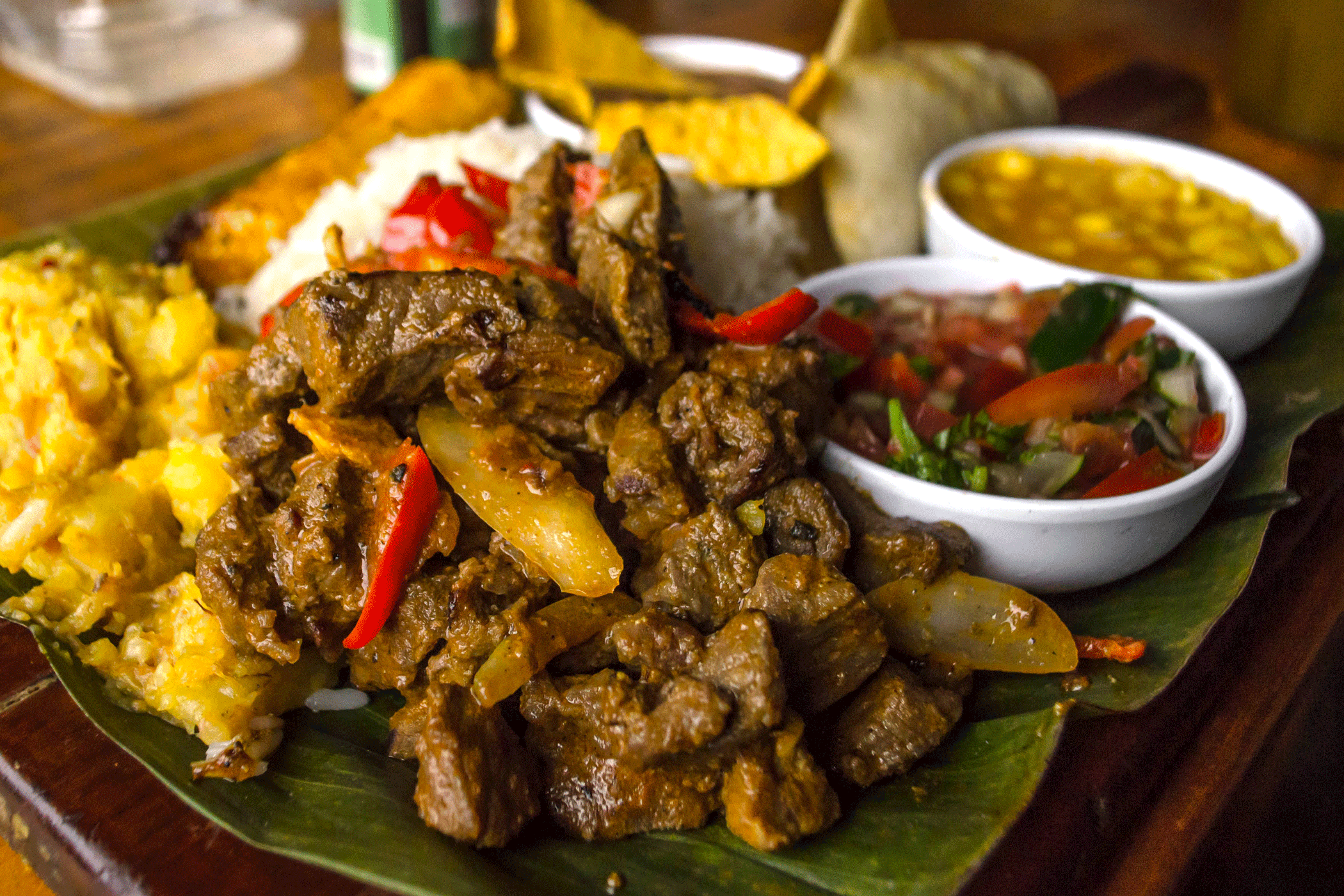 Costa Rican typical food called "Casado de Res" with beef, mashed potatoes, tomato salad, corn soup, rice, fried plantain, beans with nachos and tortillas