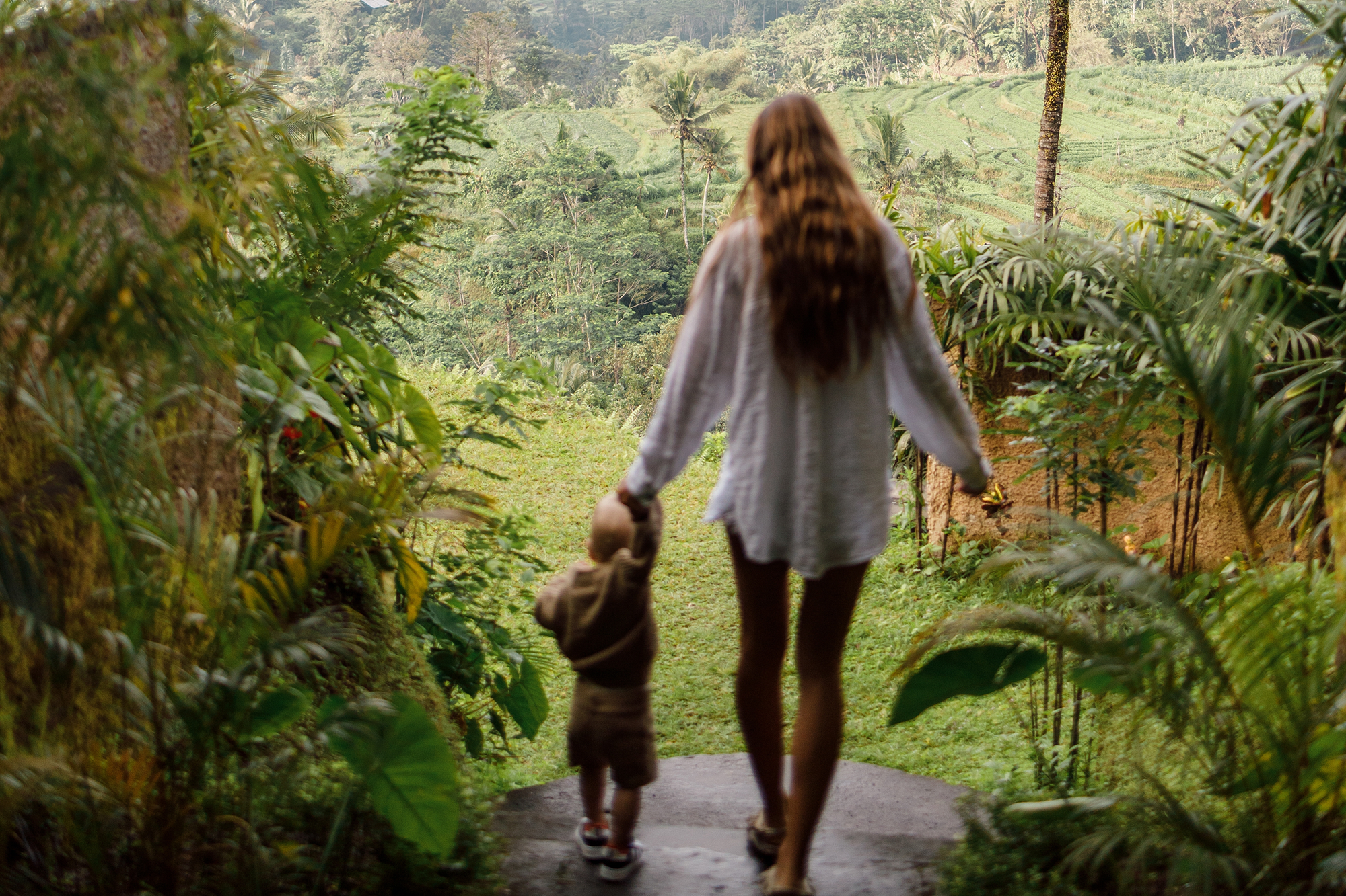 En mor med sin sønn i frodig natur i Asia. Foto
