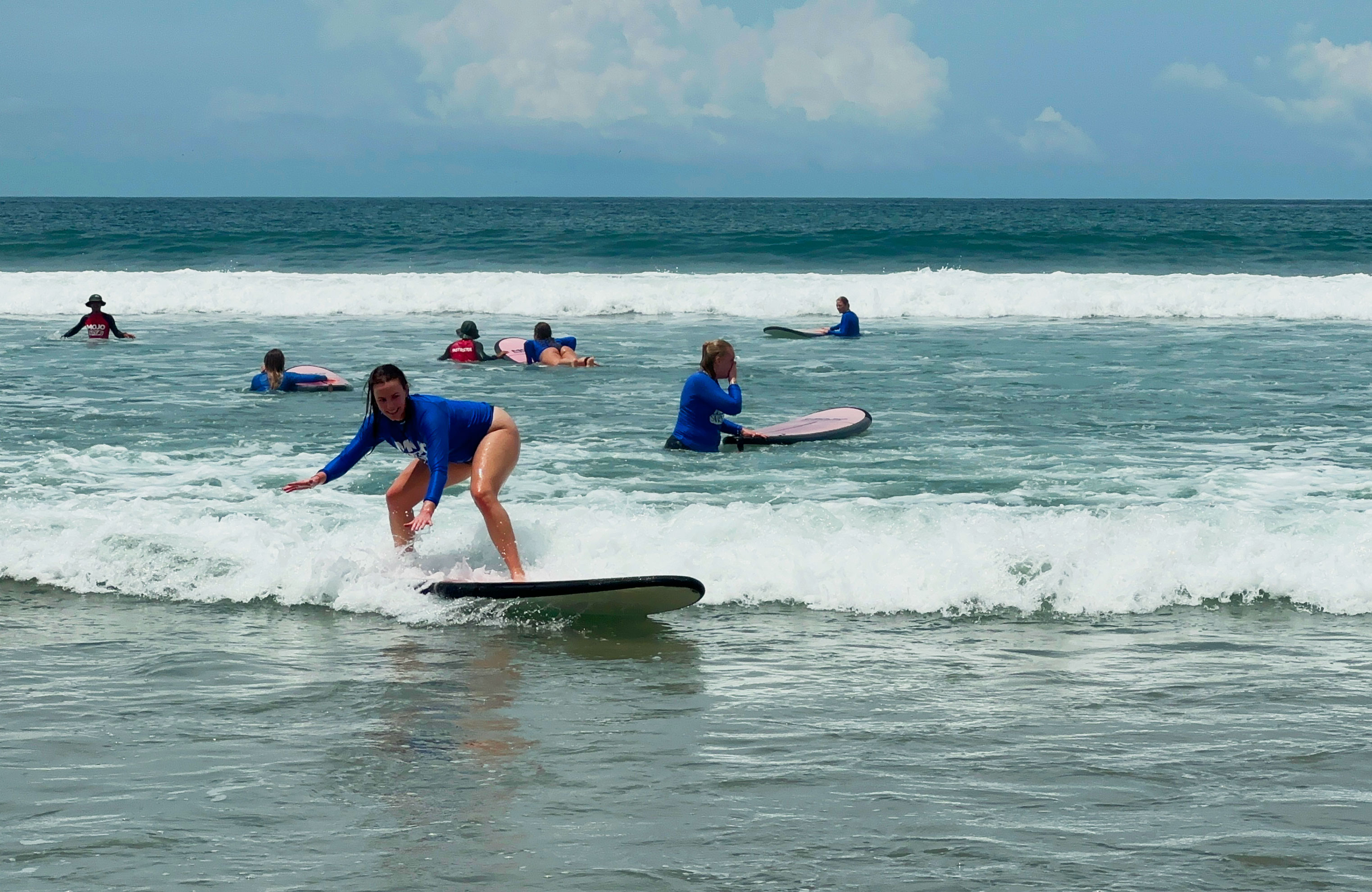 Group of travellers learning to surf on Bali