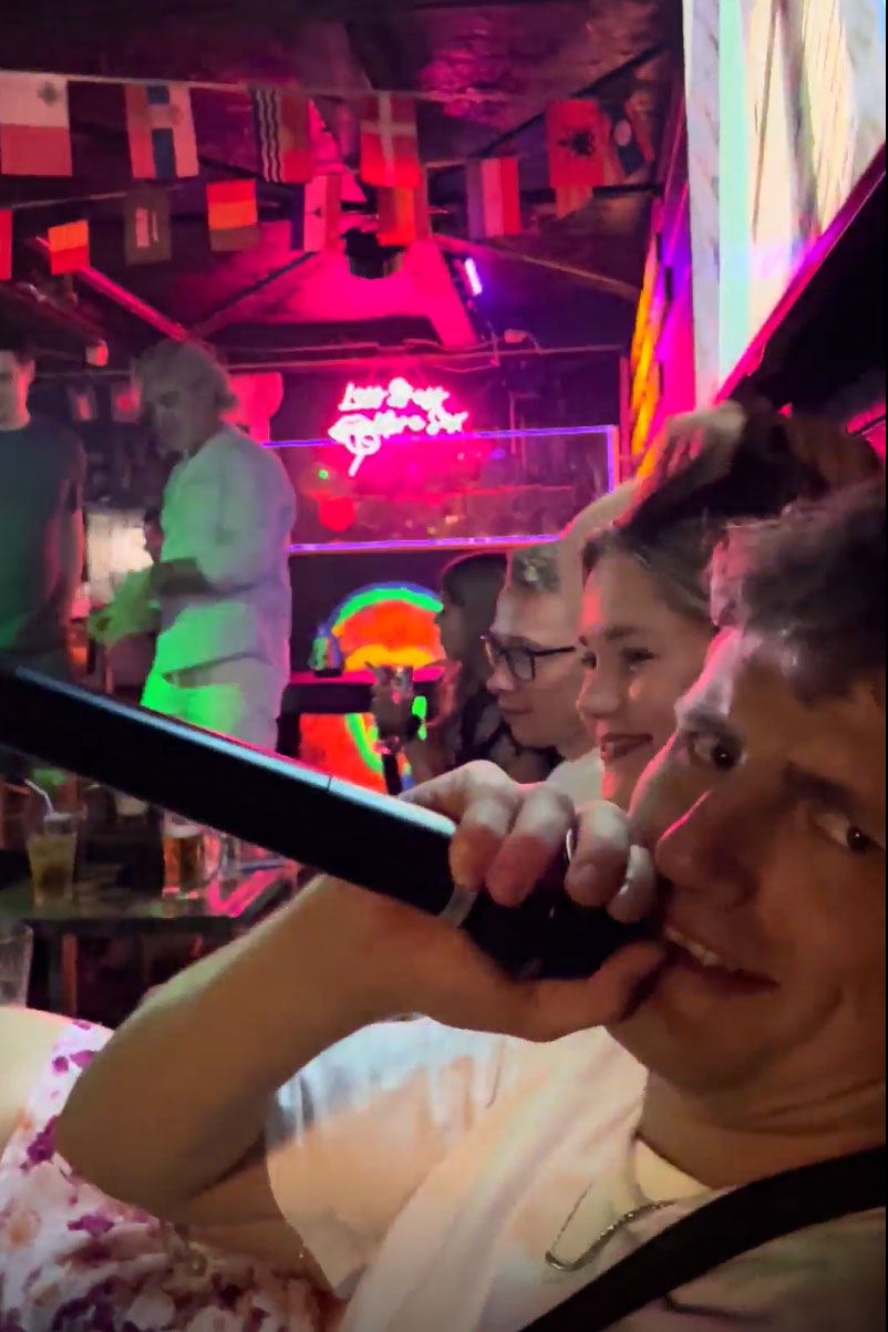 Guy holding a microphone singing karaoke in a karaoke bar in Japan