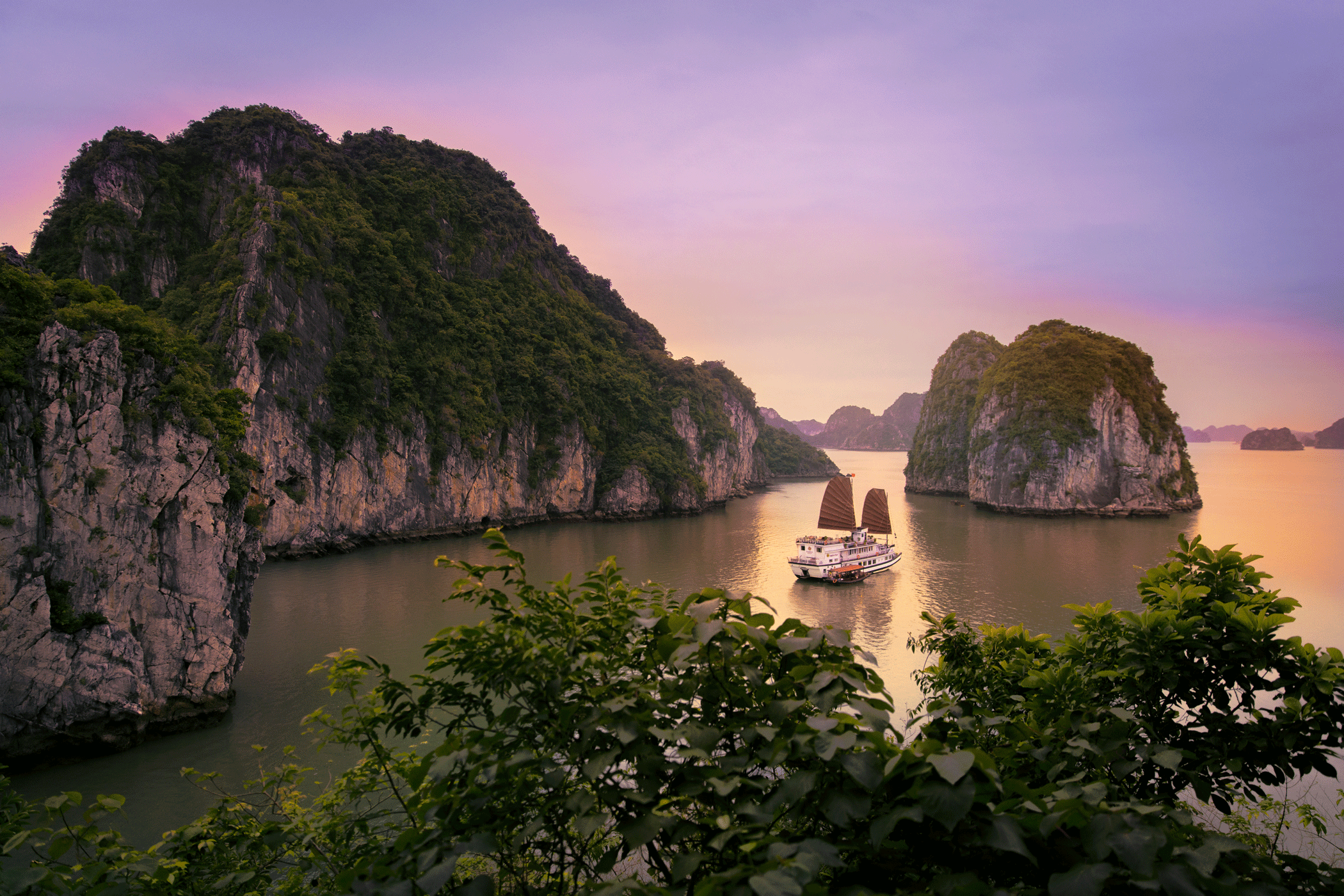 Boat in Bai Tu Long Bay during sunset