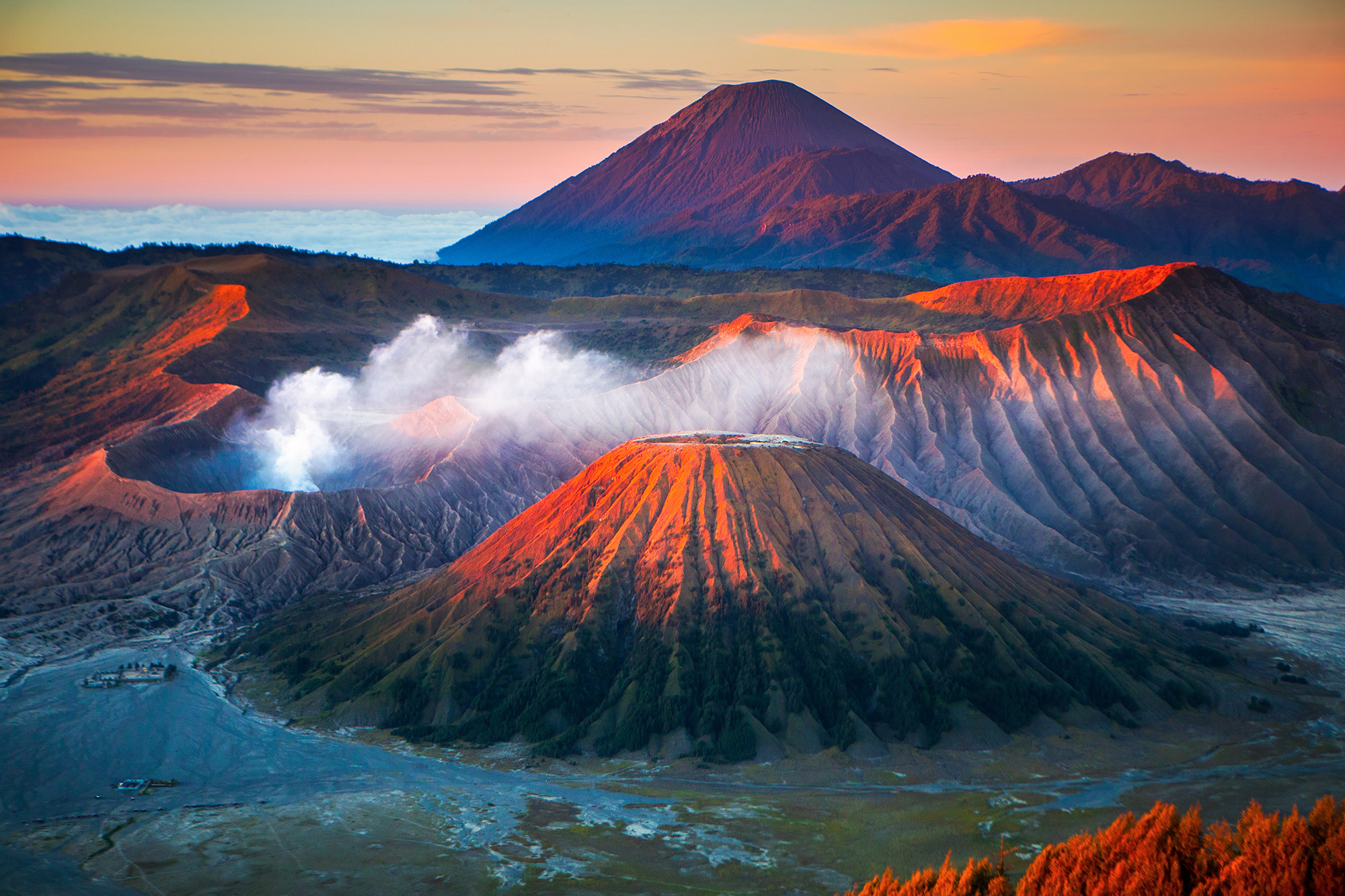 One of the crates of Mount Bromo blowing steam during sunset, on the island of Java in Indonesia
