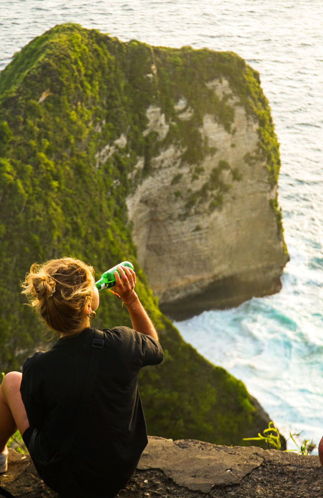 Amarins sitting on a cliff on Nusa Penida, Indonesia and drinking a beer