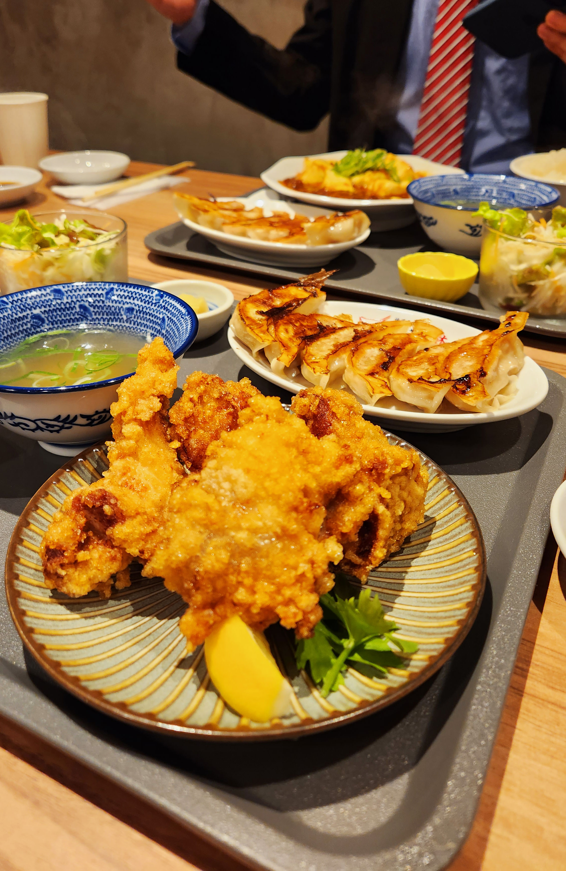 Plate full of Japanese food, with miso soup, fried chicken, rice, salad and Gyoza