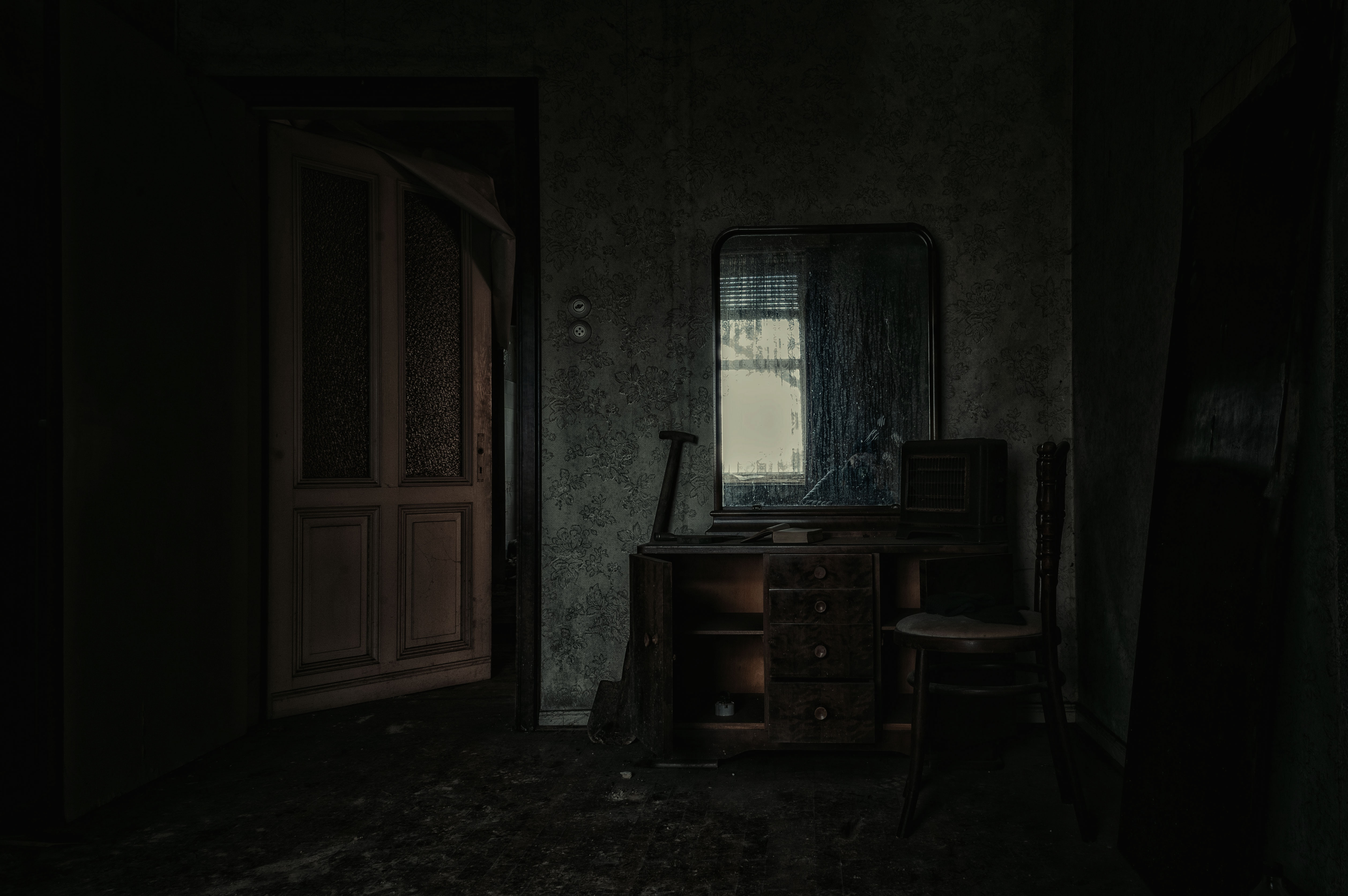 Creepy room in an old, haunted mansion with decaying walls and furniture being left behind by previous owners. 